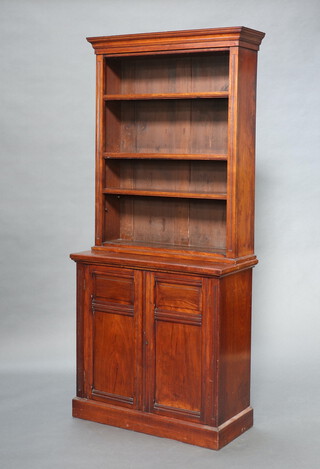 A 19th Century mahogany open bookcase on associated cabinet with moulded cornice, fitted adjustable shelves, the base enclosed by a panelled door, raised on a platform base 199cm h x 89cm w x 40cm d 