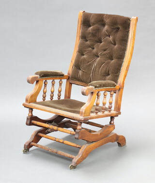 A 19th Century American mahogany rocking armchair upholstered in buttoned material 102cm h x 58cm w x 66cm d (seat 34cm x 35cm) 