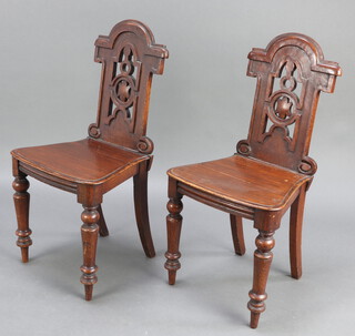 A pair of Victorian carved and pierced oak hall chairs with shaped solid seats, raised on turned supports 90cm h x 45cm w x 36cm d (seat 20cm x 16cm) 
