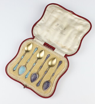 A cased set of Norwegian silver and enamelled teaspoons with scroll decoration in a fitted case 