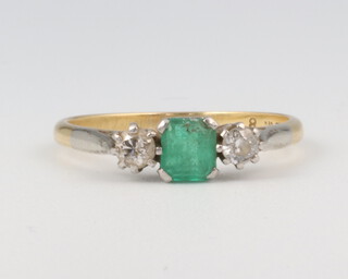 A yellow metal 18ct emerald and diamond 3 stone ring, the centre emerald approx. 0.5ct, the 2 brilliant cut diamonds approx. 0.1ct each, 2.5 grams, size O 