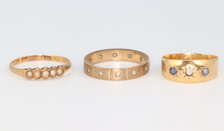An 18ct yellow gold seed pearl ring, size N, a 9ct wedding band size O and a yellow metal gem set gypsy ring size I 1/2 (1 stone missing), gross weight 5.4 grams 