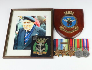 A Second World War group of un-named medals comprising 1939-45 Star, Atlantic with France and Germany Bar and Burma, Defence medal and War medal, together with a photograph of the recipient, a cloth, Royal Naval Association badge and a ditto wooden plaque 