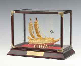 A Korean gilt metal model of a 2 masted boat -  with plaque "The first armour clad ship in the world Kobukson 1592", contained in a glazed mahogany mounted frame, from the stock exchange of Korea 23cm h 