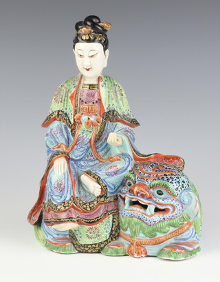 A 19th Century famille rose figure of Bodhisattva seated on a buddhistic lion decorated in coloured enamels 25.5cm h 