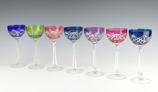 Seven coloured hock wine glasses with clear stems 