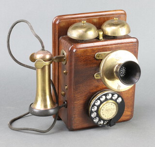 A wall mounting telephone contained in a mahogany case 9cm x 24cm x 16cm