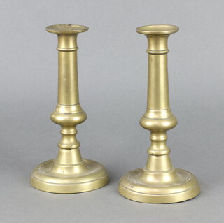 A pair of 18th/19th Century brass candlesticks raised on circular bases with ejectors 23cm x 11cm 