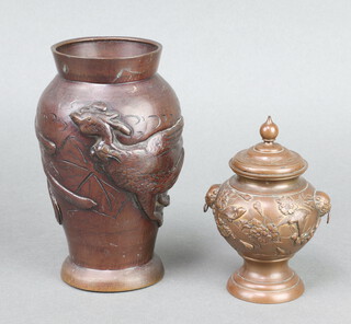 A 19th Century Japanese polished bronze baluster shaped twin handled urn and cover with floral decoration, raised on a circular spreading foot 10cm x 4cm, together with 1 other Japanese bronze vase decorated a bird 5cm x 6cm 