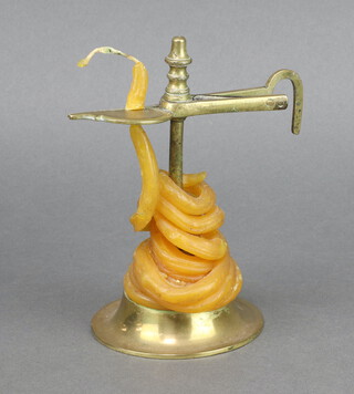 An 18th/19th Century brass wax jack, raised on a circular base 7cm x 9cm diam. 