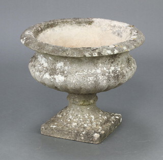 A circular well weathered concrete garden urn with lobed body, raised on square feet 36cm h  x 45cm diam. 