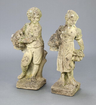 A well weathered concrete garden figure of a boy with basket of flowers 71cm h x 28cm x 18cm and 1 other of a standing lady with basket of flowers 72cm h 