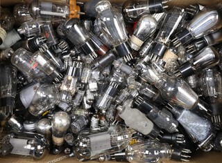 A collection of valves, some military, all unboxed and contained in a green fruit box 