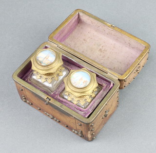 A pair of Victorian square cut glass scent bottles, the gilt metal hinged lids painted watercolour decoration of buildings, 6cm, contained in arched studded leather case 8cm x 11cm x 6cm  
