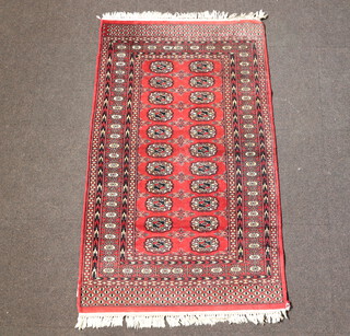 A red, black and white ground Bokhara rug with 22 octagons to the centre within a multi row border 