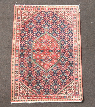 A pink, blue and white ground and floral patterned Persian rug with diamond shaped medallion to the centre  102cm x 69cm 