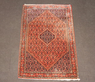 A peach and blue ground Persian rug with diamond medallion to the centre 175cm x 116cm 