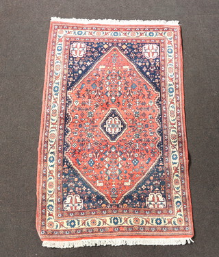 A pink, blue and white ground Persian rug with diamond shaped medallions to the centre within a multi row border 161cm x 97cm 