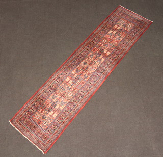 A machine made pink and blue ground runner with 4 stylised medallions to the centre within a multi row border 280cm x 71cm 