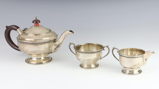 An Art Deco bachelors silver 3 piece tea set with beaded decoration and wood mounts 415 grams gross, Birmingham 1933 