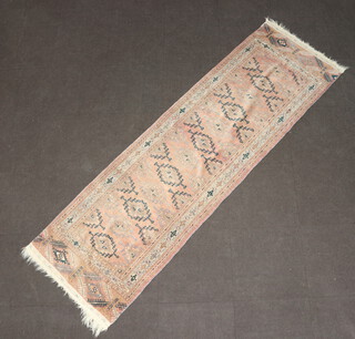 A sun bleached blue and red ground Afghan runner with 12 diamonds to the centre 271cm x 85cm 
