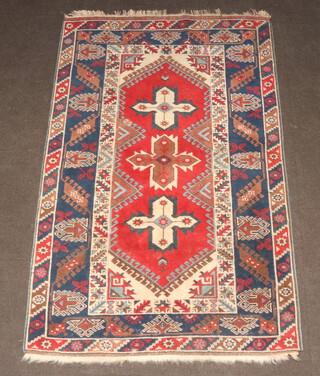 A blue, red and white ground Afghan rug with 3 stylised medallions to the centre within a multi row border 195cm x 126cm 