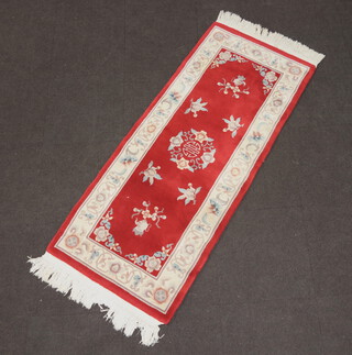 A white and red ground floral patterned Chinese rug 188cm x 80cm  