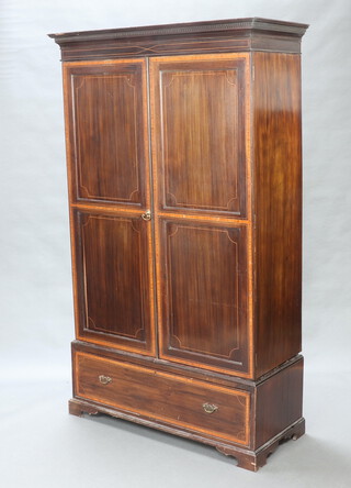 A 19th Century inlaid mahogany wardrobe, the upper section with moulded cornice enclosed by panelled doors, the base fitted a drawer, raised on bracket feet 207cm h x 124cm w x 53cm d 