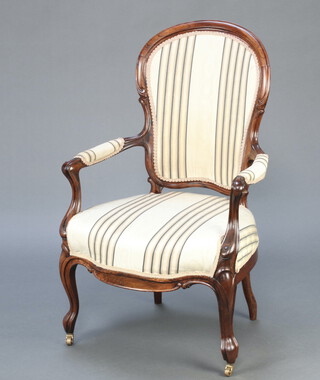 A Victorian rosewood show frame open arm chair upholstered in striped material raised on cabriole supports 100cm h x 61cm w x 54cm 