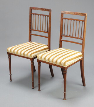 A pair of Edwardian inlaid mahogany stick and rail back bedroom chairs with overstuffed seats, raised on turned supports 88cm h x 41cm w x 40cm d 