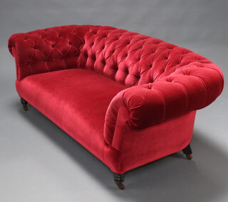 A Victorian chesterfield upholstered in red buttoned material, raised on turned supports 63cm x 191cm x 79cm (seat 108cm x 40cm) 