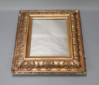 A rectangular plate mirror contained in a decorative gilt cushion shaped frame 87cm x 75cm 