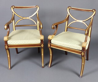A pair of Empire style mahogany and gilt painted open arm chairs with woven cane seats, raised on sabre supports 87cm h x 57cm w x 49cm d (seats 31cm w x 35cm d) 