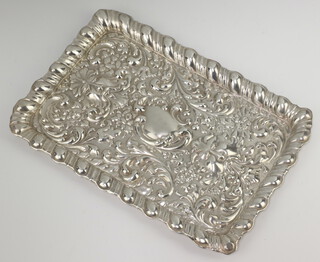 An Edwardian rectangular repousse silver dressing table tray decorated with scrolls and masks, Birmingham 1903, 30cm, 316 grams 
