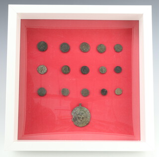 A collection of Roman coins and an artefact, framed 