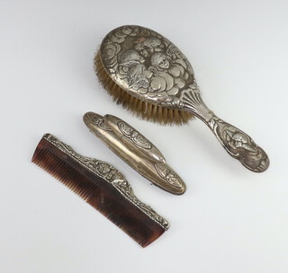 An Edwardian repousse silver Reynolds Angel nail buffer, a similar hair brush and comb, London 1910 