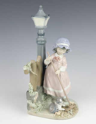 A Lladro figure of a standing girl by a street light with a broom and cat, base impressed 5286 E45 30cm 