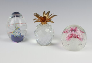 A Caithness Congratulation paperweight P55807 6cm, a Swarovski Crystal plastic, glass and gilt metal paperweight in the form of a pineapple 10cm (small chip to base) and 1 other paperweight with spiral decoration to the centre 9.5cm (chip to base) 
