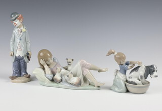 A Lladro figure of a clown with violin 5472 21cm, ditto reclining girl with kittens base impressed 5760 11cm and ditto girl washing dog 5455 12cm 
