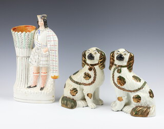 A pair of Victorian Staffordshire figures of seated spaniels 20cm (both cracked, 1 heavily) together with a flat back vase in the form of a standing Scotsman 34cm  (hat f and r)  
