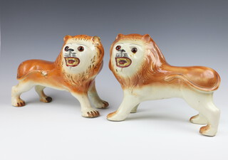 A pair of 19th Century Staffordshire figures of standing lions with glass eyes 23cm 