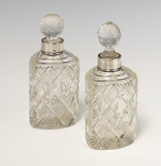 A near pair of heart shaped cut glass silver mounted scent bottles Birmingham 1897