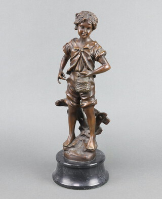 A bronze figure of a standing boy with fish and creel, raised on a circular black marble base 45cm h x 15cm diam. 