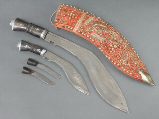 A Kukri with 28.5cm blade together with 1 other with 15cm blade, 2 skinning knives, contained in a plush scabbard 