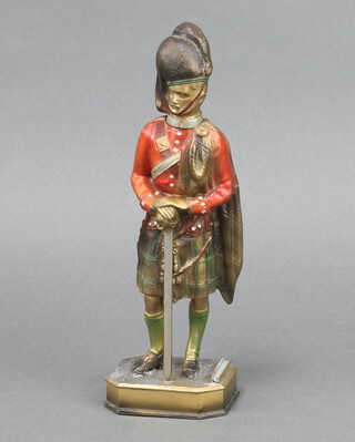 A table lighter in the form of a standing Highland officer, raised on a shaped base 24cm x 8cm x 6cm 