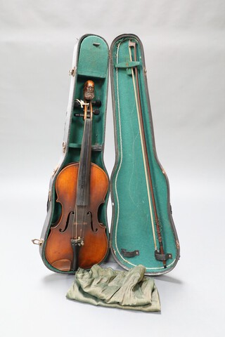 A 19th century German violin featuring a carved scroll in the form of a bearded gentleman, the lower back with an inlaid town scene and marked inside 'Jiovan Paolo Magini Brescia 1715', cased with bow.