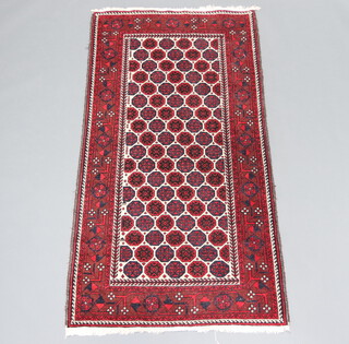 A red, white and blue ground Afghan rug with central medallion within a multi row border 208cm x 103cm 