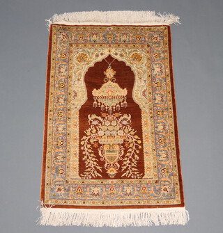 A tan and white ground silk prayer rug with mihrab and mosque 102cm x 67cm 