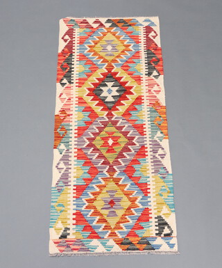 A white, green and turquoise coloured Chobi Kilim runner with 4 diamonds to the centre 159cm x 64cm 