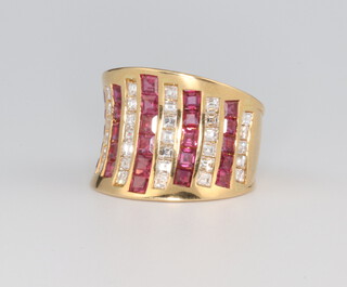 A vintage yellow metal 750 ruby and diamond cocktail ring set with 36 princess cut diamonds, approx. 0.7ct and 26 princess cut rubies approx. 0.5ct, 11.5 grams, size M 1/2 